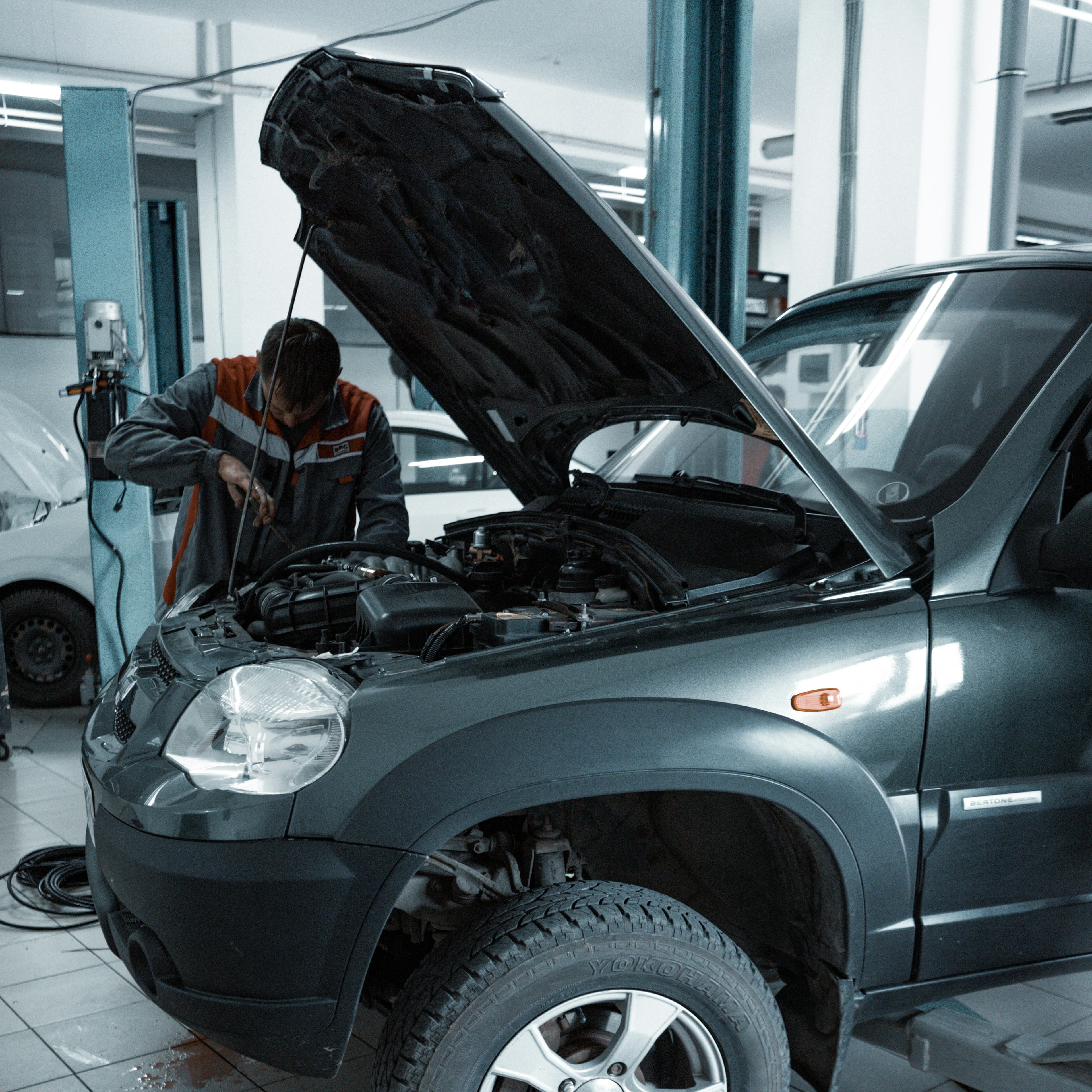 Mechanic performing a multi-point inspection on a modern vehicle engine